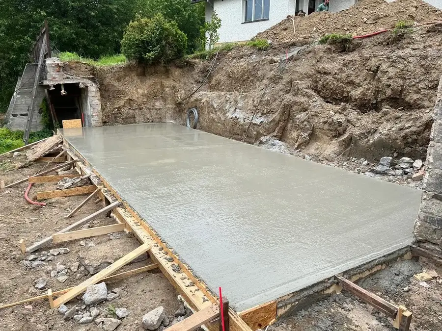 Čerstvě vybetonovaná základová deska v bednění